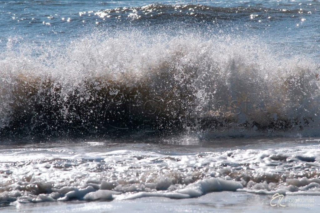 Wellenspiel mit spritzig stark glitzernden Wassertropfen am Nordwestlichen Strand der Nordseeinsel Amrum